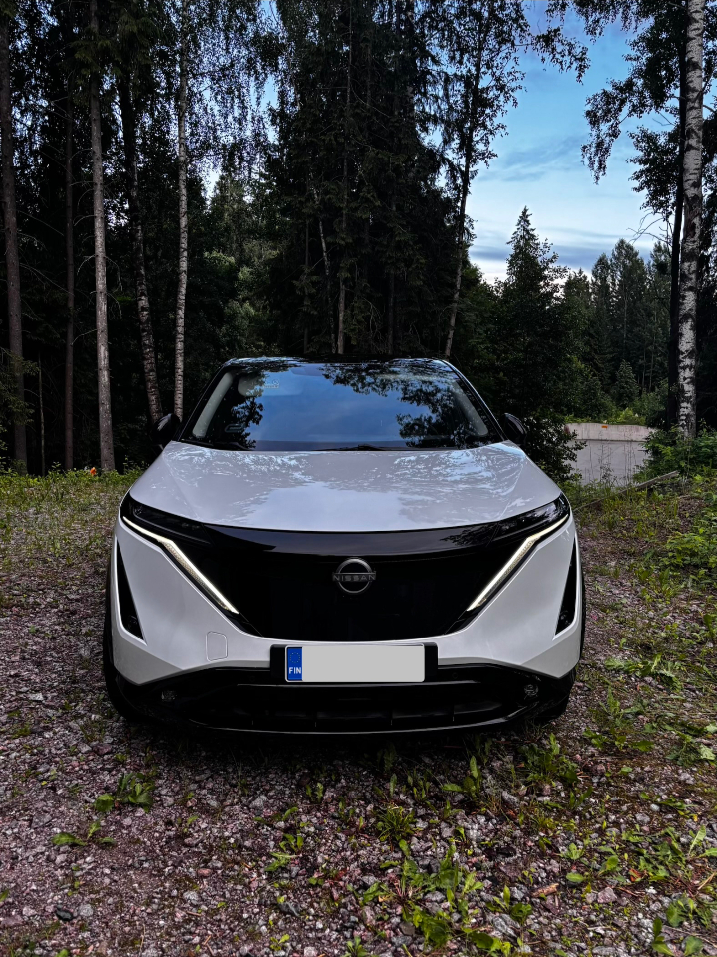 Valkoinen Nissan Ariya edestä ulkopesun jälkeen