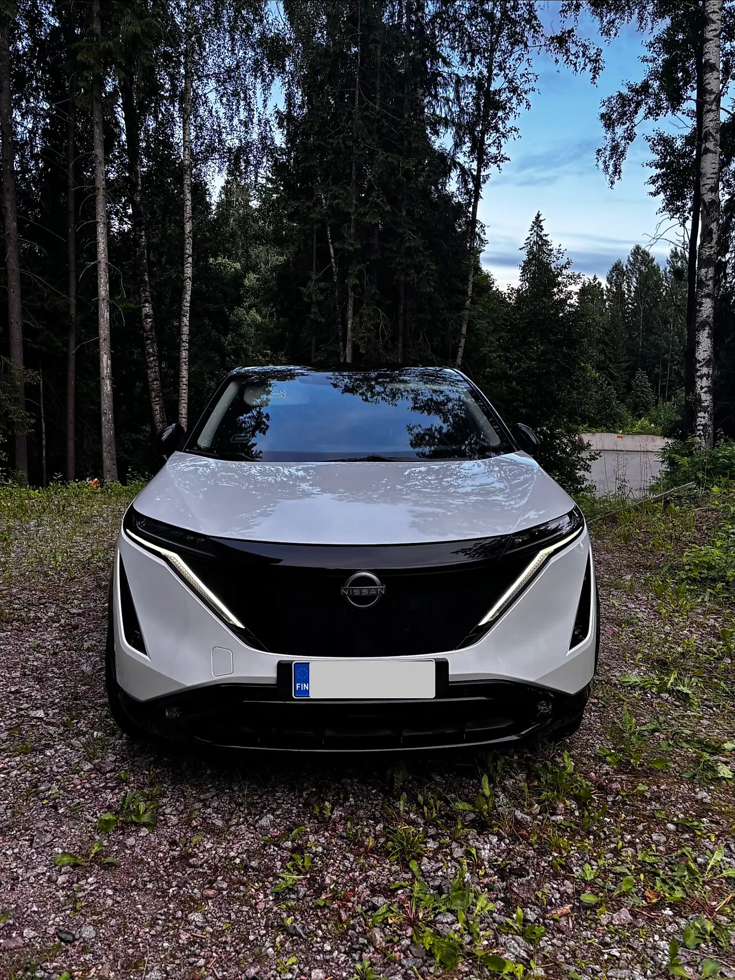Valkoinen Nissan Ariya edestä ulkopesun jälkeen